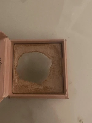 Benefit Cookie highlighter - Supersnygg highlighter från Benefit i nyansen Cookie. Kommer i en söt rosa ask med spegel i locket. Ger en intensiv champagneguldig glow som verkligen poppar på kindbenen. Perfekt för dig som älskar att glänsa och vill ha en ikonisk look.