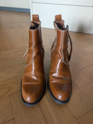 Acne Studios Pistols boots 37/38 - Acne Studios Pistols boots i en otrolig caramel/tan färg, sparsamt använda och har mycket kvar att ge. Fina kontrastsömmar i creme, tidlös design och ett par av de skönaste skorna jag haft. Märkta 37 men mer som 38, vilket är min normala storlek. 