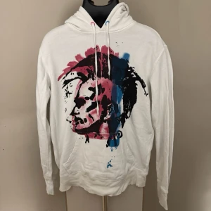 Diesel Vit hoodie med färgstarkt ansikte - Diesel Vit hoodie med huva och dragsko. På framsidan finns ett stort tryck av ett ansikte i svart, rosa och blått. 0391