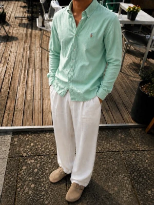 Ralph Lauren Skjorta – Mintgrön – Slim Fit – Strl M - Snygg Ralph Lauren skjorta i en stilren mintgrön/grön färg med det klassiska broderade Polo Ralph Lauren-loggan på bröstet.  * Storlek: M * Modell: Slim Fit Stretch Oxford * Material: 98% bomull, 2% elastan * Färg: Mintgrön / ljusgrön * Button-down krage * Långa ärmar * Stretch för extra komfort  Perfekt till både vardag och sommarens outfits. Snygg tillsammans med vita/creamfärgade byxor, jeans eller shorts.