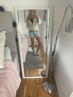 Ljusblå denimshorts med slitningar - Säljer ett par ljusblå denimshorts med råa kanter och slitningar framtill. Shortsen har klassisk femficksdesign och är midwaist. Perfekta för sommaren och ger en avslappnad vibe.