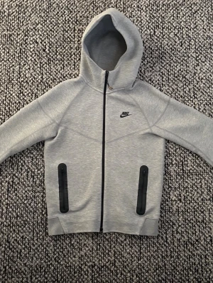 Nike tech grå - Här har vi en grå Nike tech som är knappast annvänd.