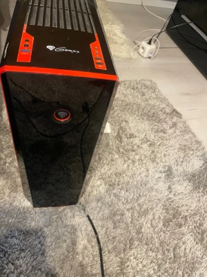 Genesis stationär gamingdator svart/röd - Snygg stationär dator från Genesis med svart och röd design. Chassit har en glansig frontpanel och ventilationsgaller på ovansidan. Utrustad med flera USB-portar, ljudutgångar och grafikkort på baksidan. Perfekt för gaming eller vardagsbruk.