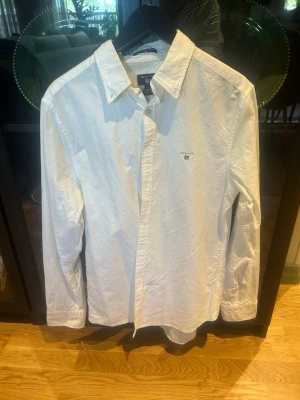 Vit oxfordskjorta från GANT - Klassisk vit oxfordskjorta från GANT med broderad logga på bröstet. Skjortan har lång ärm, knappar framtill och en stilren krage. Perfekt för dig som gillar en clean och tidlös look. Går att PRUTA.!!!
