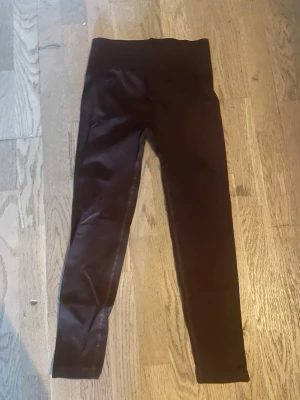 Bruna leggings med hög midja - Snygga bruna leggings med hög midja och stretchigt material. De har en tight passform och långa ben, perfekta för en trendig och bekväm look. Materialet känns mjukt och följsamt, vilket gör dem sköna att bära hela dagen.