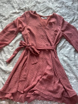 Jättefin rosa klänning💕 - Jättefin rosa klänning med volanger nertill och ett band runt midjan💕 Klänningen har en dragkedja i sidan bandet går även att ta av eller knyta vart som helst runt midjan!                 Ena snöret som man trär bandet igenom har lossnat i ena änden men går lätt att sy fast igen. Skulle heller inte säga att snörena behövs speciellt mycket så bandet sitter bra ändå☺️🫶🏻