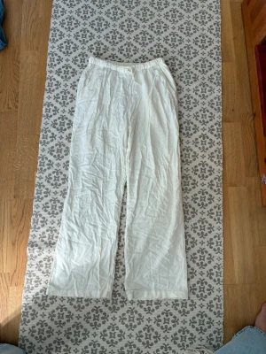 Vita linnebyxor från Lindex - Säljer ett par vita linnebyxor från Lindex i storlek 158. Byxorna har resår i midjan och raka ben för en avslappnad look. Perfekta till sommaren och lätta att matcha med olika toppar. säljer pga att de inte passar längre