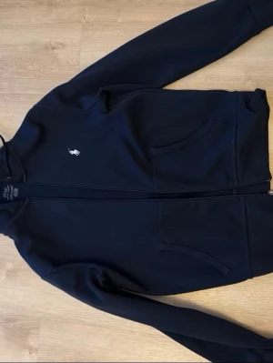 Polo Ralph Lauren zip hoodie XS - Säljer min Polo Ralph Lauren zip hoodie i storlek XS. Den är använd men fortfarande i bra skick. Mörk blå färg, dragkedja och broderad logga på bröstet. Säljes då den inte används längre. Kontakta gärna mig vid frågor