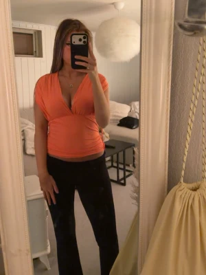 Neon rosa orange  omlottopp med v-ringning - Helt oanvänd tröja! Från Gina tricot den har en uppenbar rygg med en rosett man kan styla tröjan på massa olika sätt säljer för jag aldrig använder den  