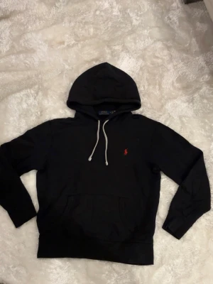 Ralph lauren hoodie - Svart Ralph lauren hoodie med rött märke.   Skriv om du har några funderingar 