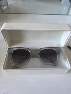 Transparenta solglasögon från CHIMI - Säljer ett par stilrena solglasögon från CHIMI med transparent båge och fyrkantig form. Glasen är mörka och ger en modern vibe. Kommer med originalfodral. Perfekta för dig som vill ha en clean och trendig look i sommar. Nypris 1400