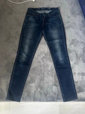 Levi's Demi Curve Skinny Jeans - Mörkblå skinny jeans från Levi's, modell Demi Curve med modern midja. Klassisk femficksdesign och diskreta slitningar för en snygg look. Perfekta för dig som gillar en tight passform och stilren denim.