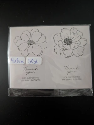 Thank you-klistermärken blommor 50st - Ett paket med 50 stycken klistermärken i storlek 4x8 cm med svartvita blomillustrationer och texten 'Thank you for supporting my small business'. Perfekta för att dekorera paket eller brev.