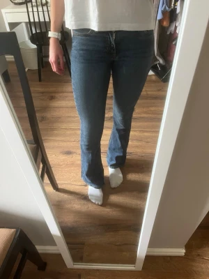 Mörkblå bootcut jeans - Säljer ett par mörkblå bootcut jeans med fina detaljer på bakfickorna