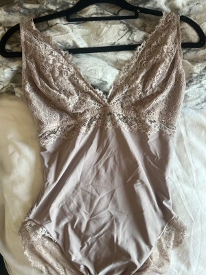 🤍 H&M beige spetsbody | Strl S | Elegant & feminin - Säljer en superfin beige spetsbody från H&M i storlek S. Den har vackra spetsdetaljer som ger en elegant och feminin look. Perfekt att bära till jeans, kostymbyxor eller kjol – lika fin till vardags som till fest.