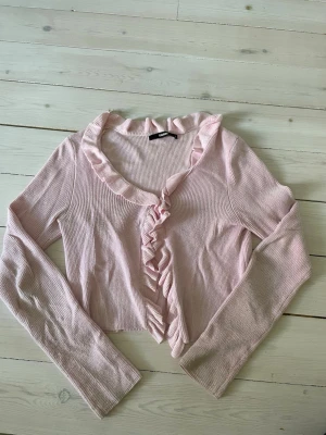 Rosa kofta från bikbok - Fik kofta från bikbok med volanger. Det sitter ”knappar” på insidan(se bild) perfekt för hösten/sensommar.