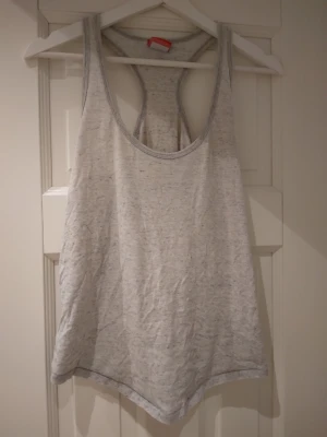 Ljusgrå ärmlös linnetopp, linne, Nike, Strlk ca S-M - Säljer en ljusgrå, lös och ärmlös linnetopp med brottarrygg från Nike. Toppen är enkel och stilren, perfekt för varma dagar eller som ett lagerplagg. Tillverkad i mjukt bomullsmaterial för skön känsla. Bra skick.