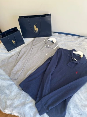 Blå💙 och grå🩶 långärmad piké Ralph Lauren - Två långärmade pikétröjor från Ralph Lauren, en i marinblått med röd logga och en i ljusgrått med vit logga. Båda tillsammans 999kr styck 599kr skriv vid minsta intresse 😁
