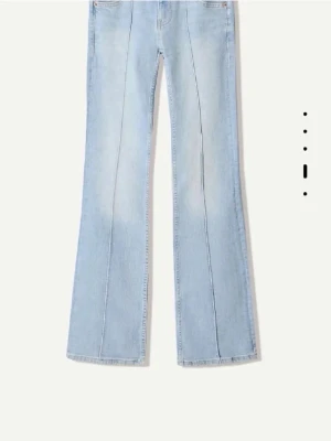 Ljusblå bootcut jeans med pressveck - Säljer ett par ljusblå jeans från Bershka med pressveck framtill och bootcut-modell. Jeansen har hög midja, dubbla knappar och klassiska fickor fram och bak. Perfekta för en trendig och avslappnad look. Jag har även ett par samma jeans men i mörkare färg av blå om någon skulle vilja köpa dem ist☺️