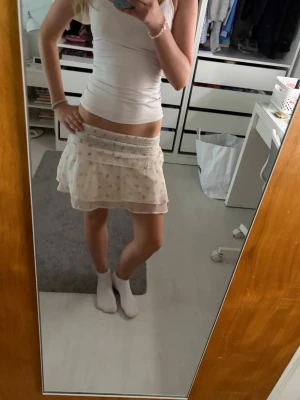 Vit volangkjol - Supersöt vit kjol med volanger och små rosa blommor från Gina tricot.
