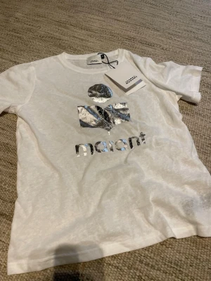 Isabel Marant t shirt - Silverfärgad logga! Supersnygg till sommar och höst, perfekt för lite partyvibe. Storlek är m