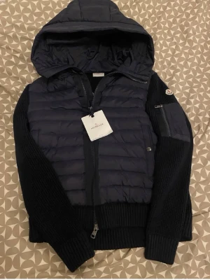  Moncler Cardigan  - Snygg mörkblå pufferjacka från Moncler med stickade ärmar och huva. Passar storlek medium och är i bra skick. Passar ej priset kom med prisförslag eller hör av dig i chatten vid frågor 