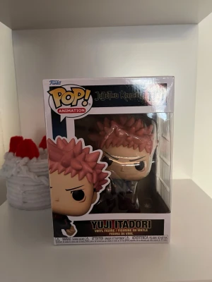 Funko Pop Yuji Itadori Jujutsu Kaisen - Säljer en Funko Pop vinylfigur av Yuji Itadori från anime-serien Jujutsu Kaisen. Figuren har rosa hår och svarta kläder och kommer i originalförpackning med fönster. Perfekt för samlare eller animefans! öppnades en gång