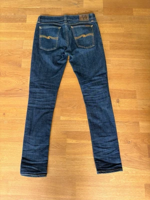 Mörkblå straight jeans - Säljer ett par mörkblå straight jeans med klassisk femficksdesign och kontrastsömmar. Jeansen har raka ben och är tillverkade i ett mjukt denimtyg som sitter snyggt. Perfekta för en clean och stilren look.