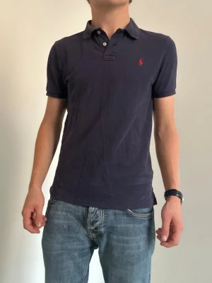 Mörkblå pikétröja Ralph Lauren slim fit - Slim fit Ralph Lauren piké storlek Small. Fråga gärna vid funderingar:)