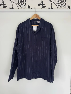 Mörkblå randig pyjamasskjorta XL - Mörkblå randig pyjamasskjorta från HM, aldrig använd. Nypris med pyjamasbyxor 399:-