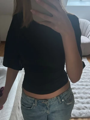Svart topp - Snygg svart t-shirt som är figurnära i midjan och bred i ärmarna. Från Gina Tricot i storlek XS. Jättesnygg till jeans. ☺️