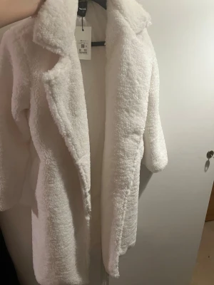 Vit fluffig oanvänd kappa - Jätte fin vit kappa oanvänd med prislapp . Storlek XS.