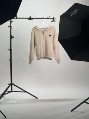 Beige stickad hoodie från Prada - ÄKTA CASHMERE/MERINOULL                                    Är 185 och den sitter bara pytte lite för kort för min smak, passar om du gillar lite cropped look.      DEN ÄR OANVÄND