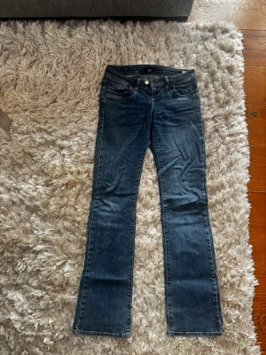Mörkblå bootcut jeans - Snygga mörkblå bootcut jeans med klassisk femficksdesign och normal midja. Jeansen har en lätt tvättad look och raka ben som går ut något nedtill. Tillverkade i denim med stretch för extra komfort. Det är LTB i Valerie modellen. Storleken är 26/34