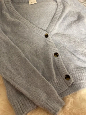Blå stickat kofta - Säljer en blå fluffig stickad kofta från Vila i storlek S. Köpte den secondhand men har inte sett några tecken på användning. Den är inte nopprig, har kvar den ”fluffigare/ mjuka” texturen och har inga slitningar eller fläckar. Har själv bara använt 2 gånger. Skriv t mig om du är intresserad