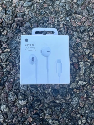 Apple EarPods med Lightning-kontakt - Säljer ett par vita oöpnade Apple EarPods med Lightning-kontakt. Klassisk design med sladd och in-ear passform, perfekt för iPhone-användare. Levereras i originalförpackning. Materialet är plast och silikon för bekväm användning.