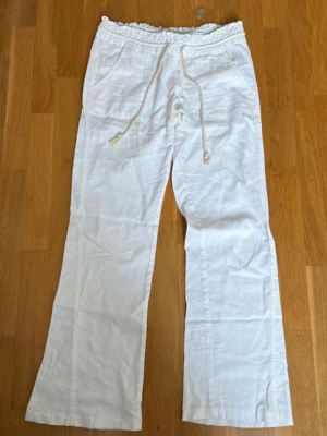 Roxy linnebyxor! - Säljer ett par vita linnebyxor från Roxy. Byxorna har resår i midjan och en snygg dragsko i repstil samt fickor fram. Perfekta för en chill och stilren look under varma dagar ⭐️ Aldrig använd, säljer pga av lite för kort för mig (179) SKRIV GÄRNA VID FRÅGOR ❤️