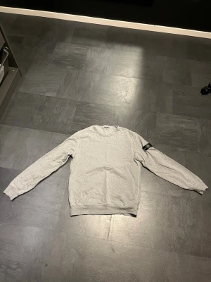 Grå sweatshirt från stone Island - Säljer nu min stone Island sweatshirt efter som den är för liten för mig. Inget synligt slitage. Såklart äkta. Kom gärna med bud