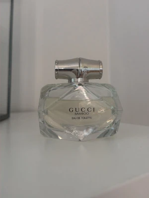 Gucci Bamboo Eau de Toilette - Gucci Bamboo Eau de Toilette i en fin transparent glasflaska med facettslipad design och silverfärgat lock. Fräsch och feminin doft. Endast använd ett fåtal gånger, se bilderna för hur mycket som finns kvar.
