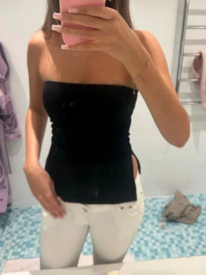 Svart bandeau tubtopp - Säljer en svart bandeau tubtopp från Zalando med slits på båda sidorna. Perfekt skick💞