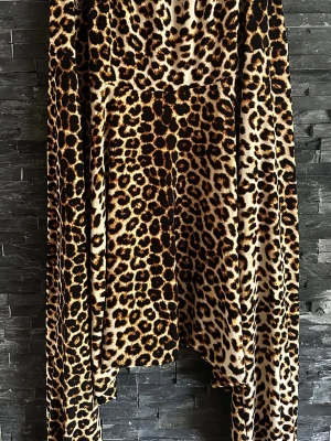 Leopardmönstrad haremsbyxor Hangmatta - Säljer ett par riktigt snygga leopardmönstrade harems byxor från Hangmatta. Byxorna har bred resår i midjan och är gjorda i ett mjukt, stretchigt material som känns skönt mot huden. Perfekta för dig som vill sticka ut med ett djurmönster!