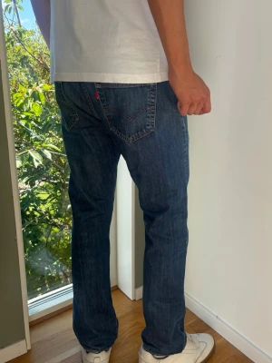 Levis 501 Jeans Vintage - Levis 501, raka jeans. Färg: Blå | Modell: 501 | Storlek: W34 L32 |. Killen på bilden har fått dragit ner byxorna en del i syfte att visa passform, kolla måtten nedan för att se om dem passar! Mycket gott skick, inga skador eller slitningar. Mått: A: 45 cm B: 102 cm C: 20,5 cm D: 29 cm Tveka inte att höra av dig minsta fråga eller fundering! Skickas snabbt!