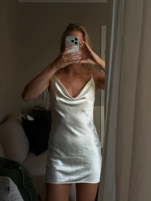 Vit kort satinklänning - Vit kort klänning i satin, har en figurnära passform och en enkel, elegant look. Längd går att anpassa.