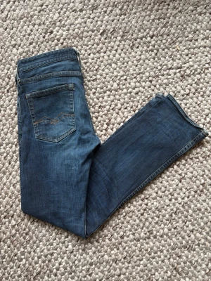 Mörkblå raka jeans - Replay - Snygga mörkblå jeans med raka ben och klassisk femficksmodell. Jeansen har subtila slitningar och kontrastsömmar på bakfickorna. Tillverkade i denim med en autentisk tvätt för en avslappnad look. Jeansen har också riktigt fina fades som blir finare destå mer de används.