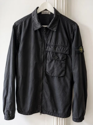 Stone Island Overshirt - strl M - Svart Stone Island Overshirt i strl M, inköpt ny på NK. Använd men i fint skick, badgen i mycket fint skick. Bilder ingår i beskrivning. Kika gärna mina andra annonser för bundle 😊