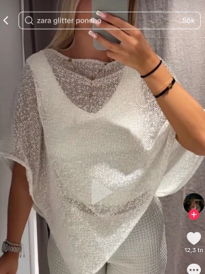 Vit glittrig poncho från Zara ny med prislapp  - Säljer en superfin vit poncho från Zara med glittereffekt. Ponchon är tunn, transparent och har en lös, avslappnad passform med breda ärmöppningar. Perfekt att styla över ett linne eller topp för en trendig look. Helt ny med prislapp 