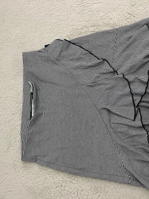 Svartvit randig långärmad topp H&M - Snygg långärmad topp från H&M i svartvitt randigt mönster. Toppen har en klassisk passform och är tillverkad i mjuk bomull, perfekt för en stilren och enkel look.