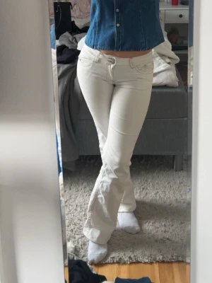 Vita bootcut jeans låg midja Nelly - Säljer ett par vita bootcut jeans från Nelly med låg midja. Jeansen har klassisk femficksdesign, dragkedja och knapp framtill. Använda ganska mycket men väldigt fina fortfarande, har dock sytt upp de därav lite ”fula” längst ner💞