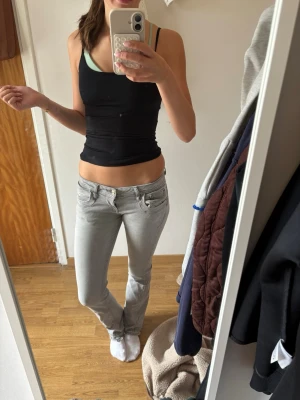 Ljusgrå LTB  low waist jeans bootcut - Säljer ett par ljusgrå jeans med låg midja och bootcut-modell. Jeansen har klassiska fem fickor och bälteshällor. Snygg passform som framhäver benen och passar perfekt till en trendig vardagslook. Uppspritta nertill men inget man tänker på!