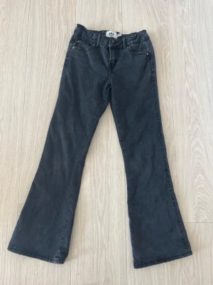 Svarta bootcut jeans från Lager 157 - Snygga svarta bootcut jeans med stretchig midja. Jeansen har utsvängda ben och en enkel, stilren look som passar till det mesta. Perfekta för dig som vill ha bekväma jeans med bra passform.